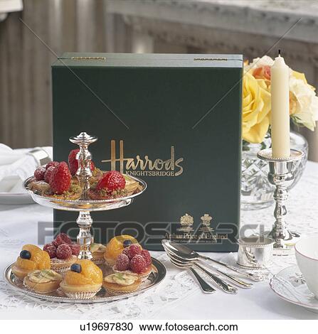 Stock Image - Close-up of cakes and pastries on silver cakestand on table in Harrod's restaurant in London. Fotosearch