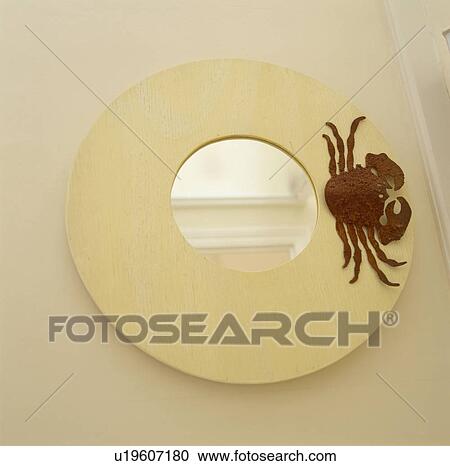 Stock Image - Close up of circular mirror with crab motif. Fotosearch