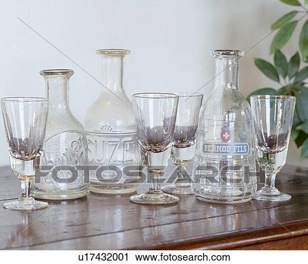 Stock Image - Close-up of collection of old wine-glasses and Pernod decanters. Fotosearch