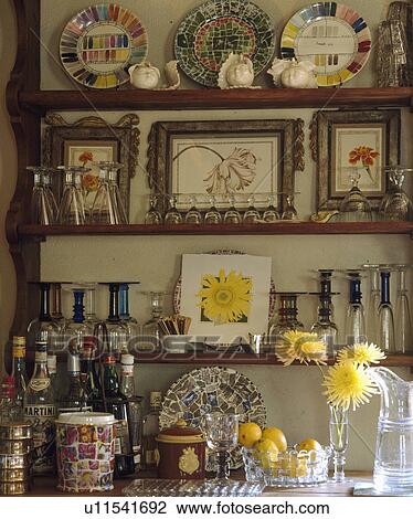 Close-up of collection of wine glasses and small pictures on wooden shelves above liquer bottles View Large Photo Image Stock Image - Close-up of collection of wine glasses and small pictures on wooden shelves above liquer bottles. Fotosearch