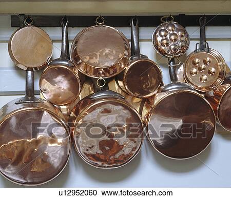 Stock Image - Close-up of copper pans on rail. Fotosearch