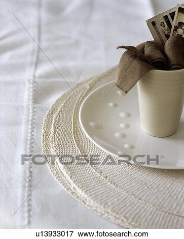Stock Photo - Close-up of cream cup and saucer on linen cloth. Fotosearch