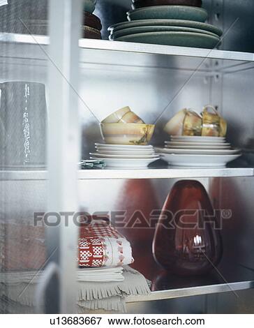 Stock Photo - Close-up of crockery and glass vase on shelves. Fotosearch