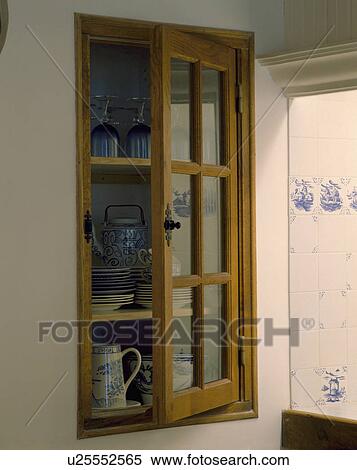 Close-up of crockery on shelves of alcove cupboard with glazed door View Large Photo Image Stock Photography - Close-up of crockery on shelves of alcove cupboard with glazed door. Fotosearch