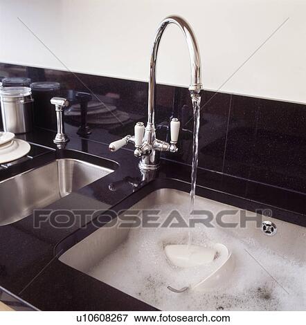 Close-up of double stainless steel sinks with steel mixer tap pouring water into sink View Large Photo Image Stock Photo - Close-up of double stainless steel sinks with steel mixer tap pouring water into sink. Fotosearch