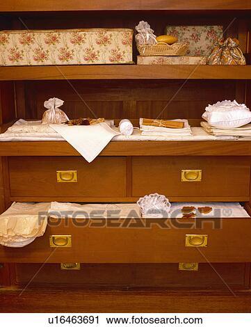 Stock Image - Close-up of floral boxes and storage drawers with bedlinen. Fotosearch