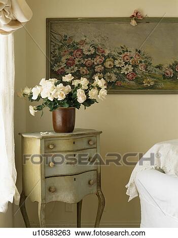 Close-up of floral picture above cream roses in vase on small painted antique table View Large Photo Image Stock Image - Close-up of floral picture above cream roses in vase on small painted antique table. Fotosearch