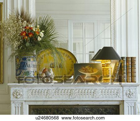 Close-up of flowers in vase on mantelpiece with lamp and old books View Large Photo Image Stock Photo - Close-up of flowers in vase on mantelpiece with lamp and old books. Fotosearch