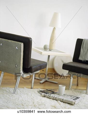 Stock Image - Close-up of granite chairs with black leather cushions . Fotosearch