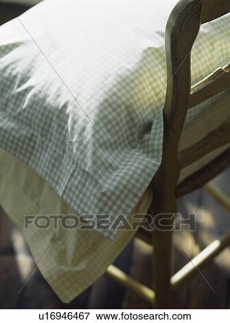 Stock Photo - Close-up of green checked gingham cushion on traditional chair. Fotosearch