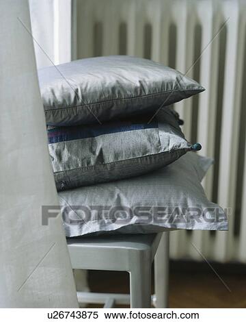 Stock Photography - Close-up of grey silk cushions on chair. Fotosearch