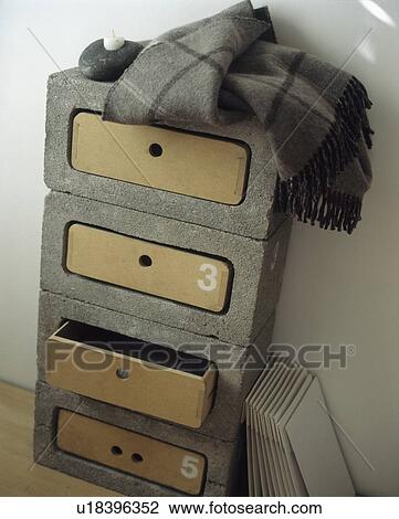 Stock Image - Close-up of grey wool rug on concrete chest-of-drawers. Fotosearch