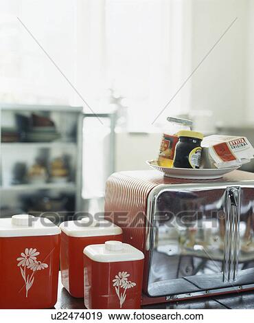 Close-up of jars of jam and Marmite on toaster beside red pots View Large Photo Image Stock Photo - Close-up of jars of jam and Marmite on toaster beside red pots. Fotosearch