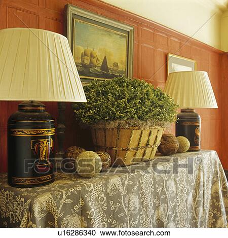 Close-up of lamps and houseplant in basket on console table against red wall View Large Photo Image Stock Image - Close-up of lamps and houseplant in basket on console table against red wall. Fotosearch