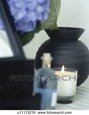 Close-up of lighted candle in glass jar and black vase with blue glass bottle View Large Photo Image Stock Photograph - Close-up of lighted candle in glass jar and black vase with blue glass bottle. Fotosearch