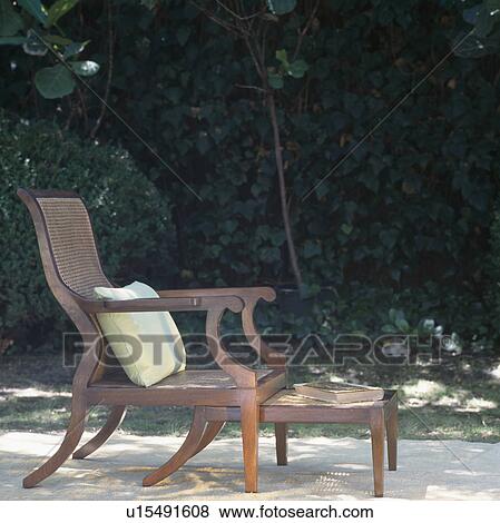Stock Photo - Close-up of mahogany and cane chair with stool. Fotosearch