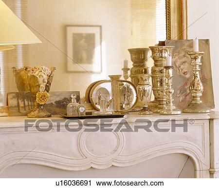 Close-up of mirror behind collection of silver candlesticks on marble fireplace View Large Photo Image Stock Image - Close-up of mirror behind collection of silver candlesticks on marble fireplace. Fotosearch