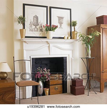 Stock Image - Close-up of pictures above fireplace with antique wooden boxes. Fotosearch