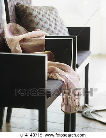 Stock Photography - Close-up of pink silk scarf on modern brown chair. Fotosearch