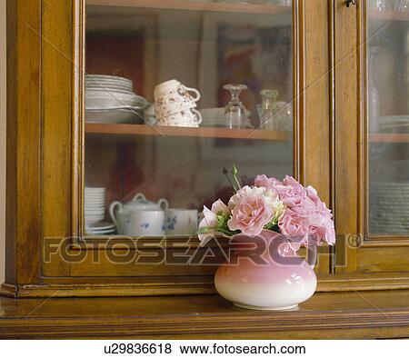 Close-up of pink vase of pink flowers in front of cupboard with glazed doors View Large Photo Image Stock Photo - Close-up of pink vase of pink flowers in front of cupboard with glazed doors. Fotosearch