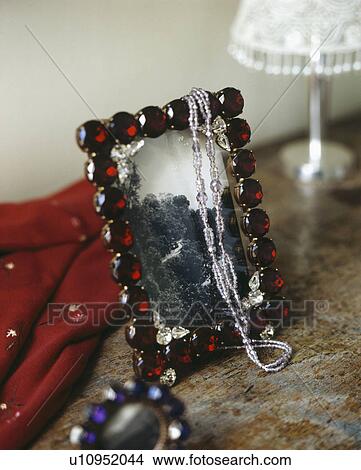 Picture - Close-up of red-jewelled photograph frame. Fotosearch
