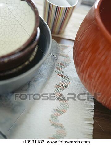 Stock Image - Close-up of red vase on cotton mat. Fotosearch
