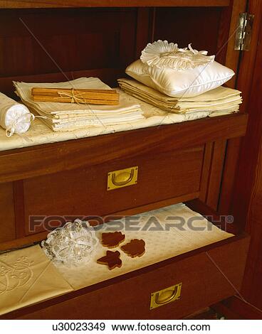 Stock Photo - Close-up of storage drawers with white linen. Fotosearch