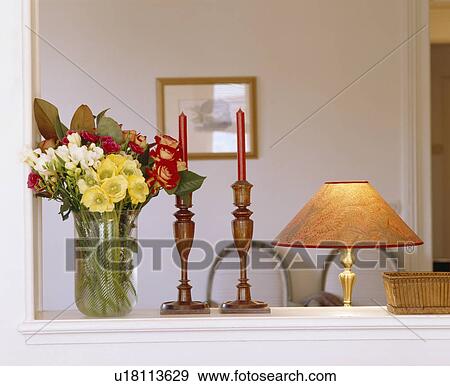 Close-up of vase of flowers on shelf with wooden candlesticks and lamp View Large Photo Image Stock Photo - Close-up of vase of flowers on shelf with wooden candlesticks and lamp. Fotosearch