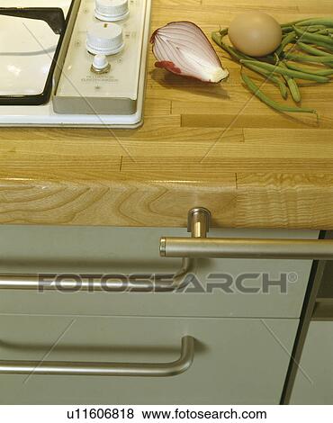 Stock Photo - Close-up of vegetables on wooden worktop beside hob. Fotosearch