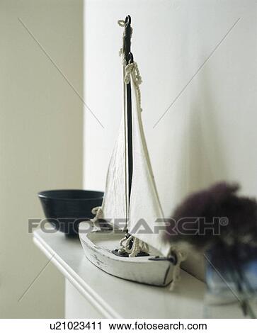 Stock Image - Close-up of white boat on mantelpiece. Fotosearch
