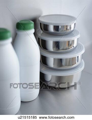 Stock Photography - Close-up of white plastic bottles beside steel storage pots. Fotosearch
