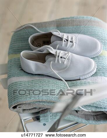 Close-up of white plimsoles on turquoise quilt View Large Photo Image Stock Photo - Close-up of white plimsoles on turquoise quilt. Fotosearch