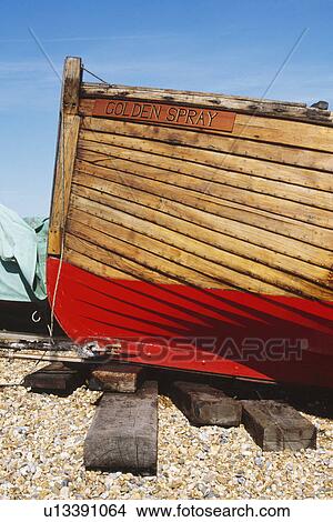 Close up of wooden boat with red painted keel on wooden sleepers on beach at Deal in Kent View Large Photo Image Picture - Close up of wooden boat with red painted keel on wooden sleepers on beach at Deal in Kent. Fotosearch