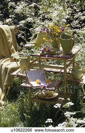 Collection of green jugs and flower arrangement on small bamboo tables in front of white cow-parsley View Large Photo Image Stock Photograph - Collection of green jugs and flower arrangement on small bamboo tables in front of white cow-parsley. Fotosearch