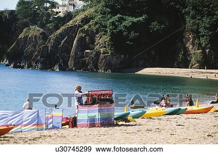 Colourful kayaks and windbreaks on Blackpool Sands beach in Devon with people bathing in the sea View Large Photo Image Stock Photo - Colourful kayaks and windbreaks on Blackpool Sands beach in Devon with people bathing in the sea. Fotosearch