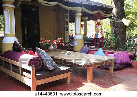 Stock Image - Colourful silk cushions in relaxing area with low seating.. Fotosearch