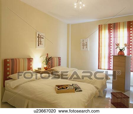 Colourful striped headboards on twin beds with white bedlinen in white bedroom View Large Photo Image Stock Image - Colourful striped headboards on twin beds with white bedlinen in white bedroom. Fotosearch