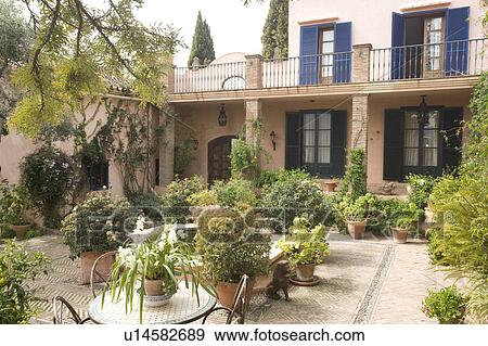Courtyard garden in front of blue shuttered villa. View Large Photo Image Stock Photo - Courtyard garden in front of blue shuttered villa.. Fotosearch