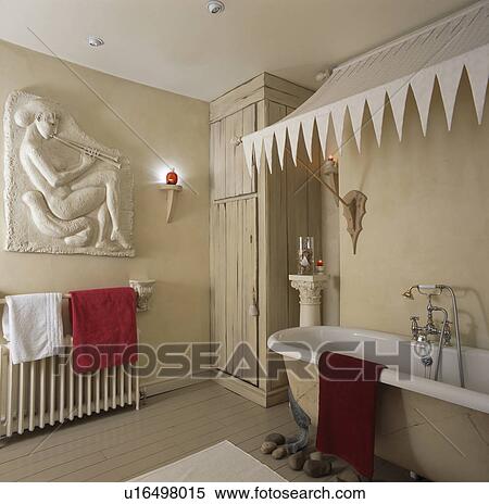 Cream canopy above rolltop bath in cream bathroom with classical plaque on wall View Large Photo Image Stock Photography - Cream canopy above rolltop bath in cream bathroom with classical plaque on wall. Fotosearch