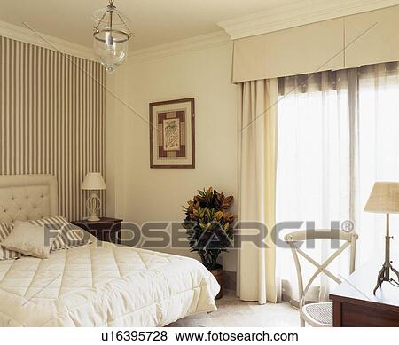 Cream curtains at French windows in cream Spanish bedroom View Large Photo Image Stock Photo - Cream curtains at French windows in cream Spanish bedroom. Fotosearch