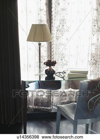 Cream lamp on mirrored desk in front of window View Large Photo Image Stock Photo - Cream lamp on mirrored desk in front of window. Fotosearch