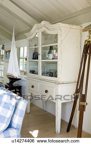 Cream painted glass-front cupboard in white coastal living room View Large Photo Image Stock Photograph - Cream painted glass-front cupboard in white coastal living room. Fotosearch