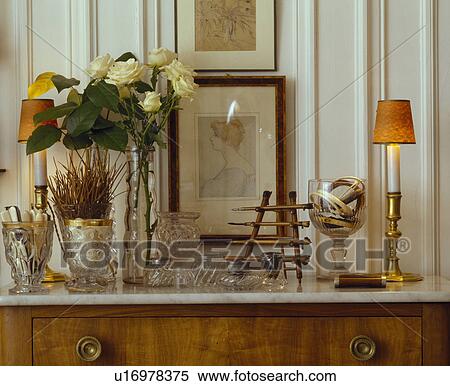 Cream roses in vase on cupboard with lamp and collection of antique glass View Large Photo Image Stock Photography - Cream roses in vase on cupboard with lamp and collection of antique glass. Fotosearch