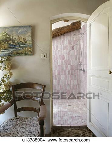 Picture - Door open to pink tiled bathroom. Fotosearch