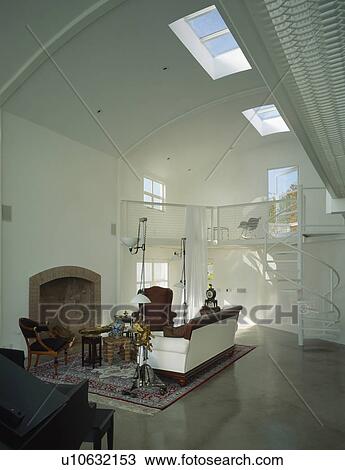 Stock Image - Double-height modern living room designed by Brian Murphy with spiral staircase to mezzanine floor. Fotosearch