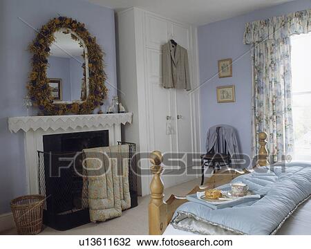 Dried flower garland around mirror above fireplace in pastel blue country bedroom View Large Photo Image Stock Image - Dried flower garland around mirror above fireplace in pastel blue country bedroom. Fotosearch