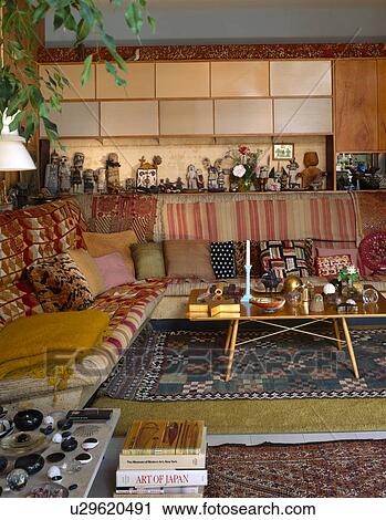 Stock Image - Ethnic rugs on corner sofa in Charles and Ray Eames living room at Pacific Palisades. Fotosearch
