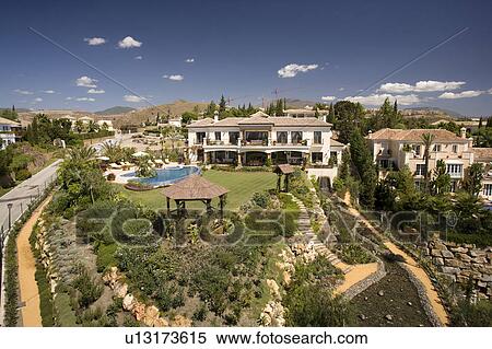 Stock Photography - Exteriors of modern villas and their surrounding gardens from the road.. Fotosearch