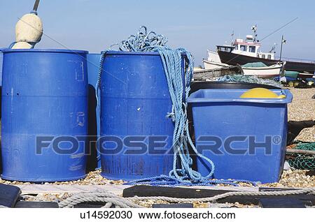 fishing equipment and blue plastic barrels on box on beach at Deal in Kent with fishing boat in background View Large Photo Image Stock Image - fishing equipment and blue plastic barrels on box on beach at Deal in Kent with fishing boat in background. Fotosearch