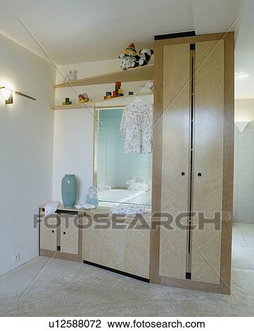 Fitted storage cupboards and large built-in mirror in child's bedroom View Large Photo Image Stock Image - Fitted storage cupboards and large built-in mirror in child's bedroom. Fotosearch